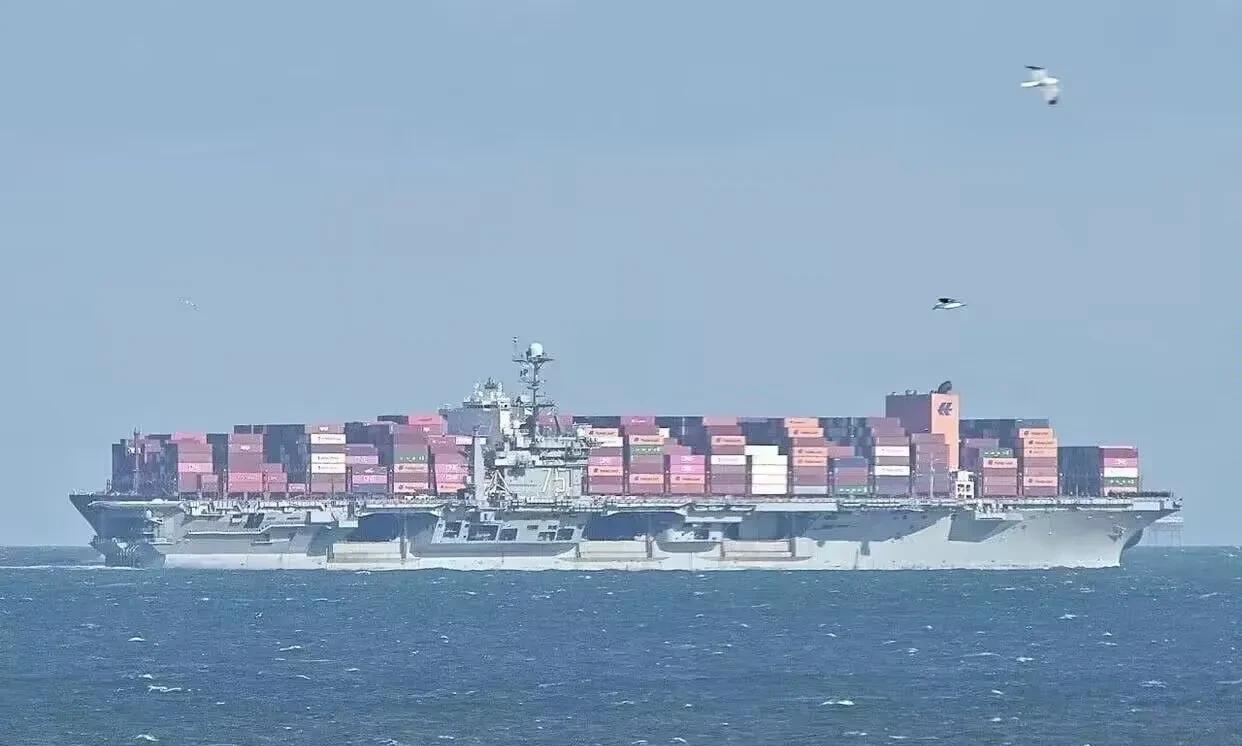看来美国人也学聪明了，只见美国海军的尼米兹级航母杜鲁门号隐藏在一艘大型集装箱货轮