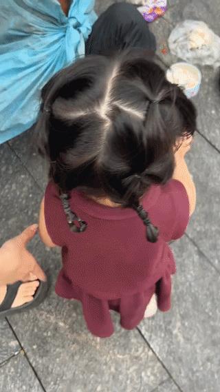 广西玉林街头，一个小女孩手上拿着10块钱要递给一位正在路边乞讨的老爷爷。
结果老