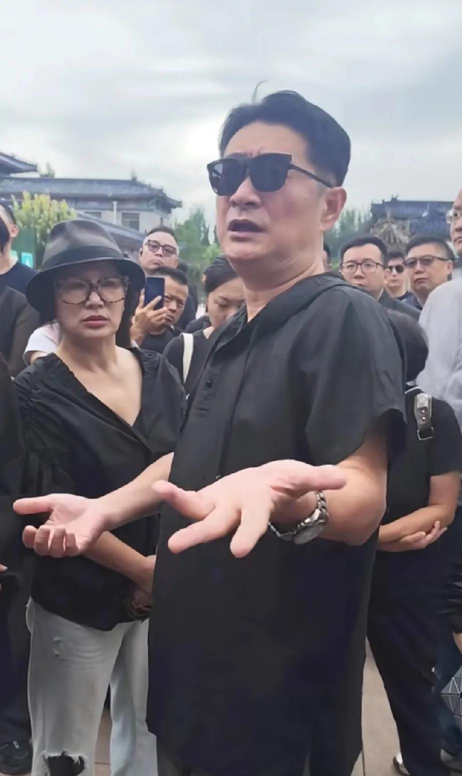 黄安和二婚妻子一起参加了千百惠的葬礼。
两个人全部黑色着装，正跟大家交流和讨论关