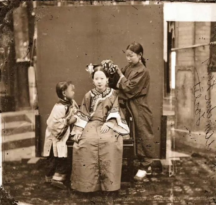 婢女正在为一位满族女子梳头（北京，1871-72年）。
