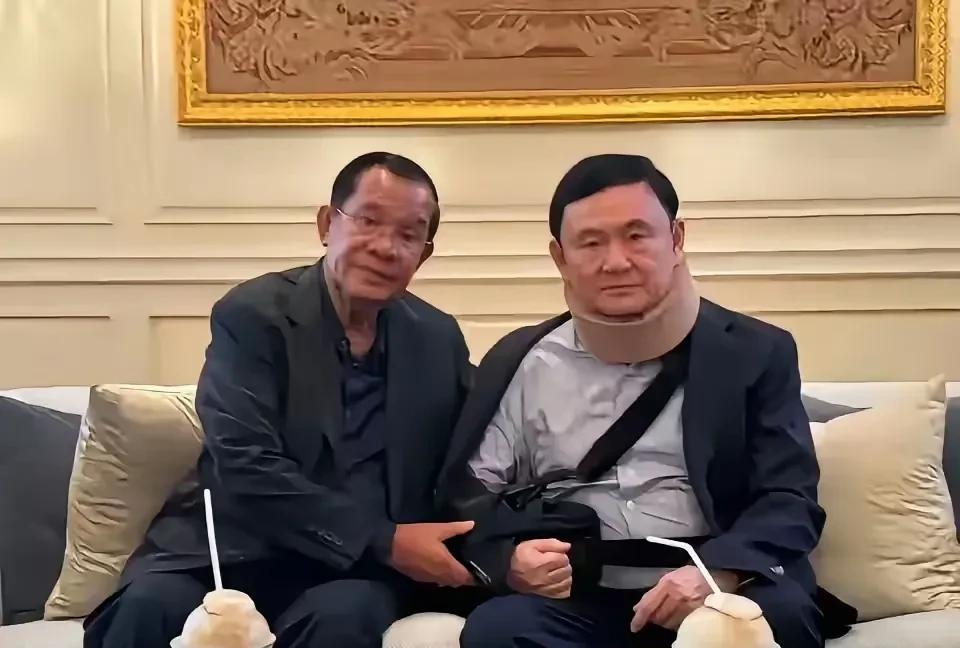这是多年前，洪森与他信的一张合影。
照片中的两人挨坐在一起，洪森还把着他信的手，
