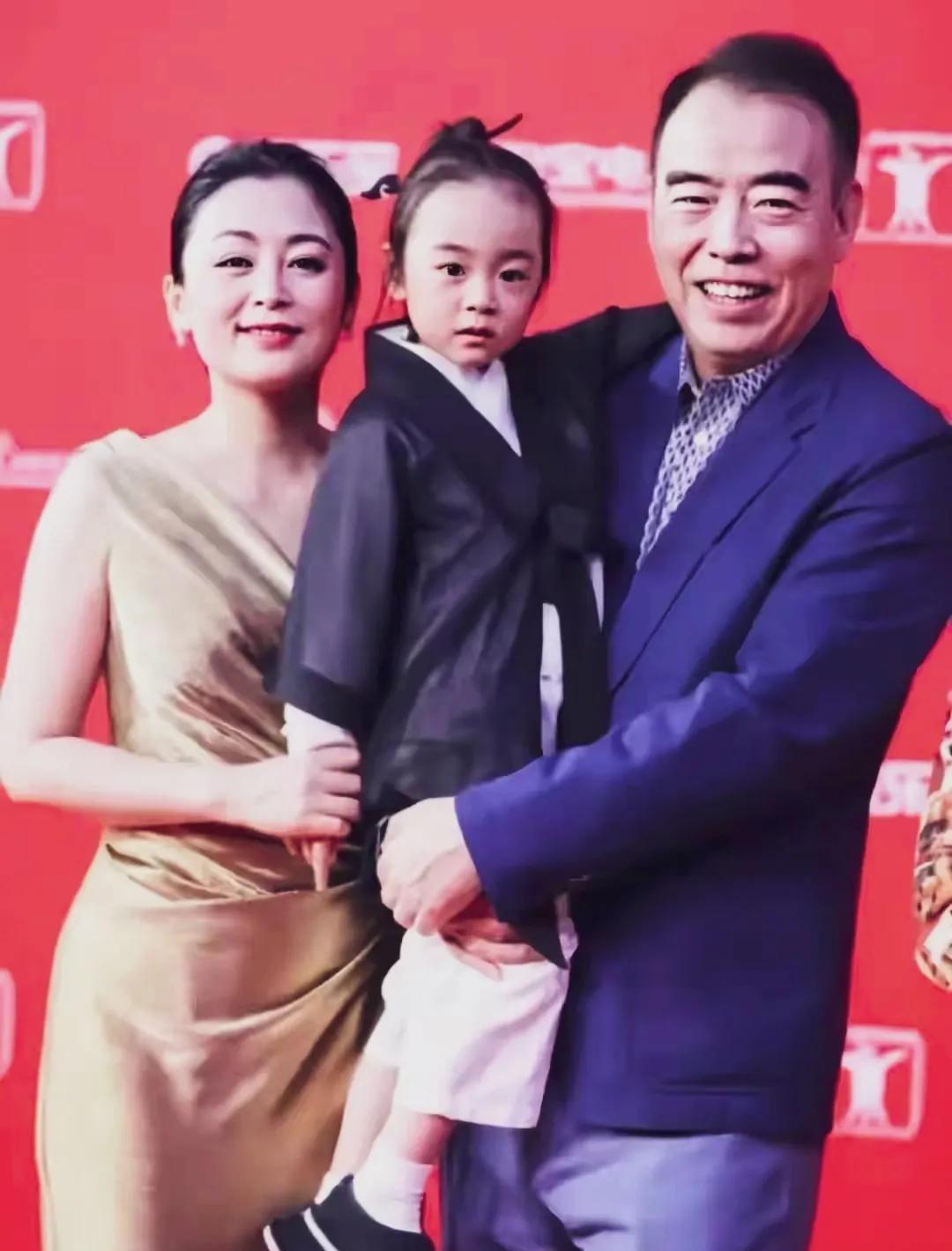 陈凯歌陈红夫妇一起走红毯，陈导抱着小演员笑呵呵的。陈红身穿金色包臀深V领礼服，身