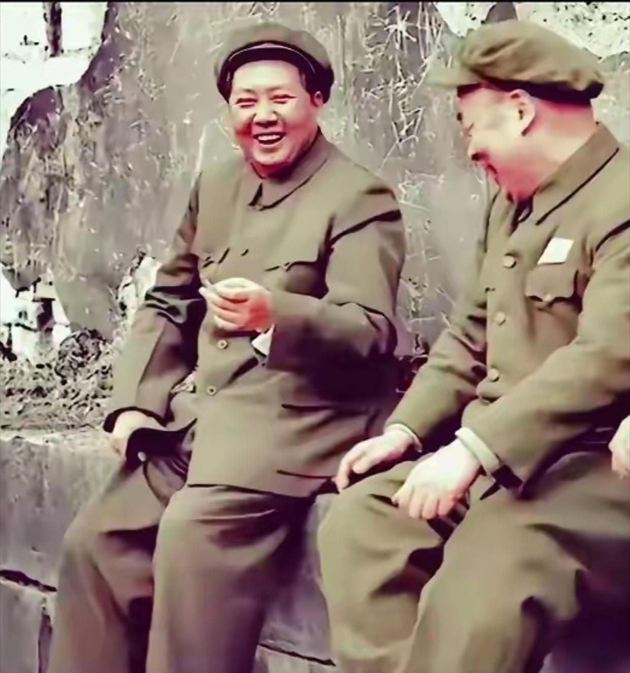 这是毛主席在南京玄武湖游览时，走累了，坐在石阶上休息时的场景。手拿香烟，笑容可掬