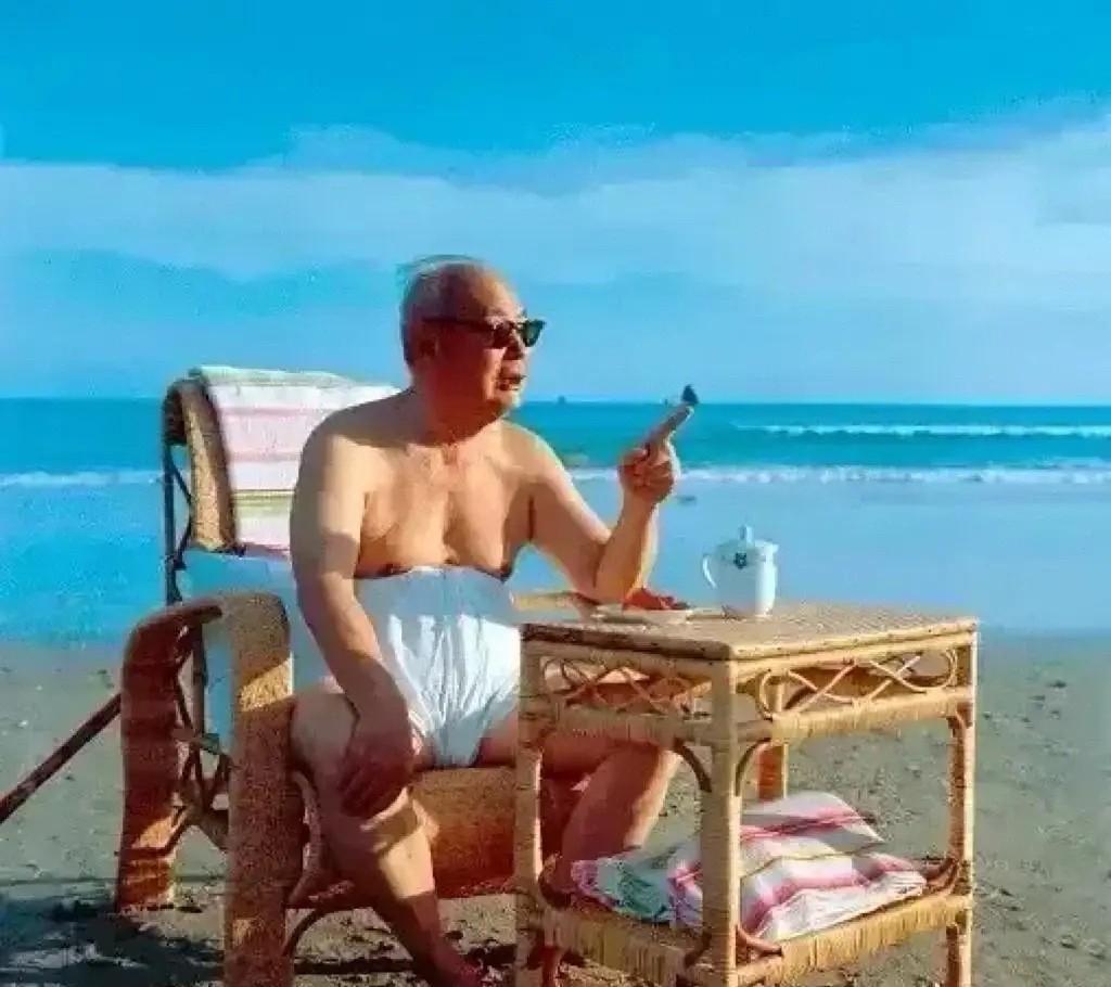 画面中，叶帅戴着墨镜，闲适地坐于竹制桌椅间，身后是辽阔的碧海蓝天。
桌前清茶一盏