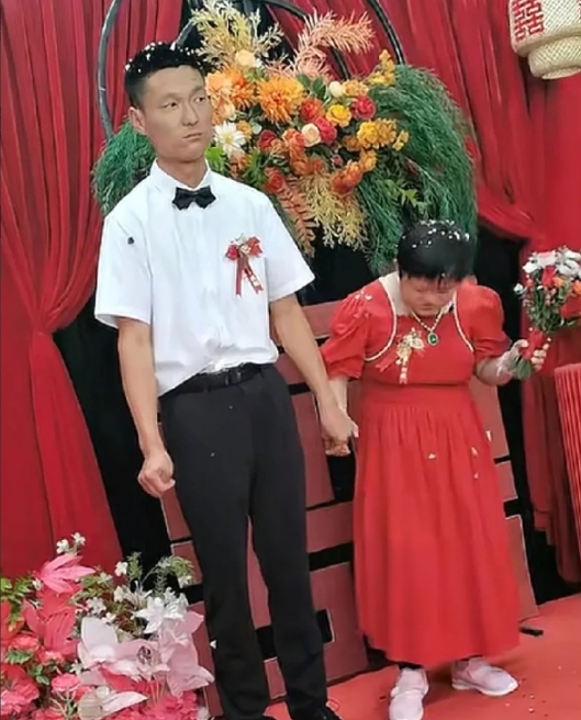 婚礼现场新郎的表情绝了，左手牵手捏着指头，右手撰着小拳头，新郎没有笑容，满脸不开