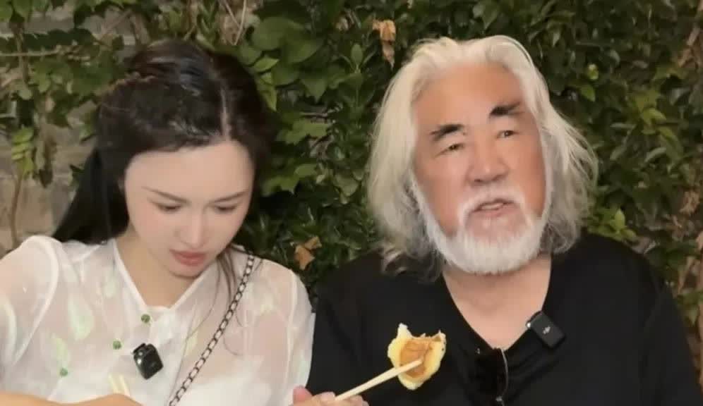 74岁张纪中在夜市吃东西，妻子杜星霖把脸涂得好白，两口子坐在路边小桌子上面品尝美