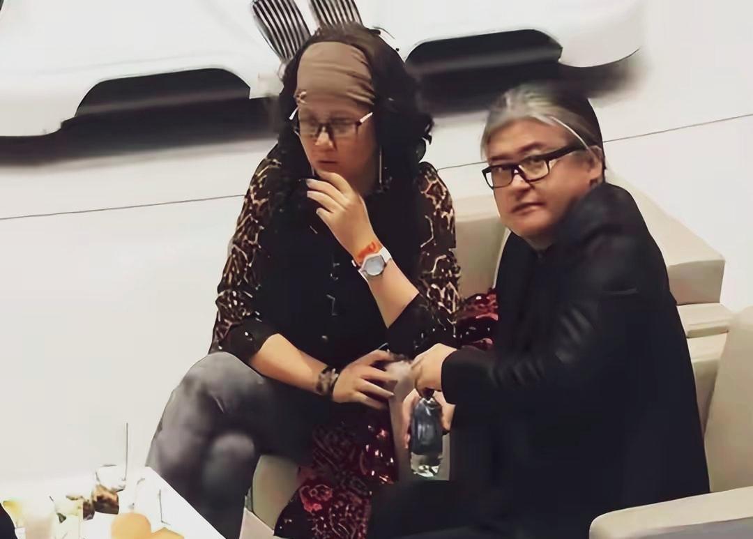 刘欢与夫人卢璐，刘欢留着艺术性的发型，白发苍苍扎着马尾辫，比他大两夫人倒看着比他