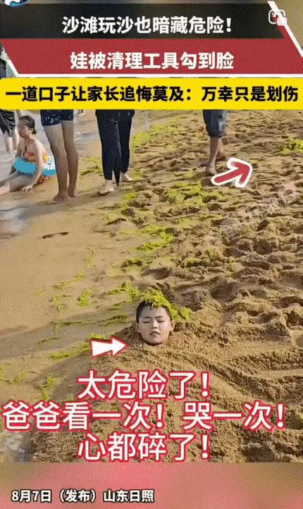 山东日照，孩子将整个身体都埋进沙子里，唯一露出的脑袋上，还顶着一颗硕大的海草，环