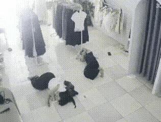 炎炎夏日，趁着中午没有顾客，服装店里的两名女服务员躺在地上休息。一只老鼠突然窜过