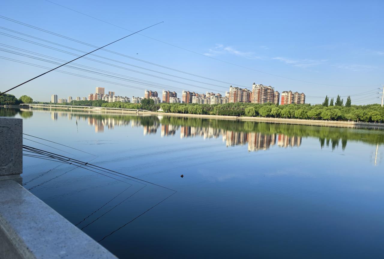 图片拍照伊通河东岸，流经城市中段，可见钓鱼竿排满。