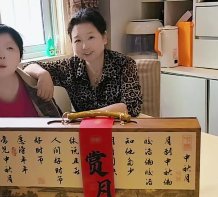 杜大娘今天收到了月饼！
明天是中秋节，杜大娘更新了作品，
大娘母女俩坐在桌子边，