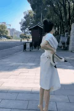 这是发生在某城公交车站的令人难以理解的一幕……一位女士脱下鞋子，把自己的裙子往上