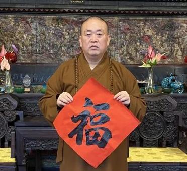 这是少林寺前方丈释永信向信众们送福气。这个福字是释永信亲笔所题写。可见，释永信的