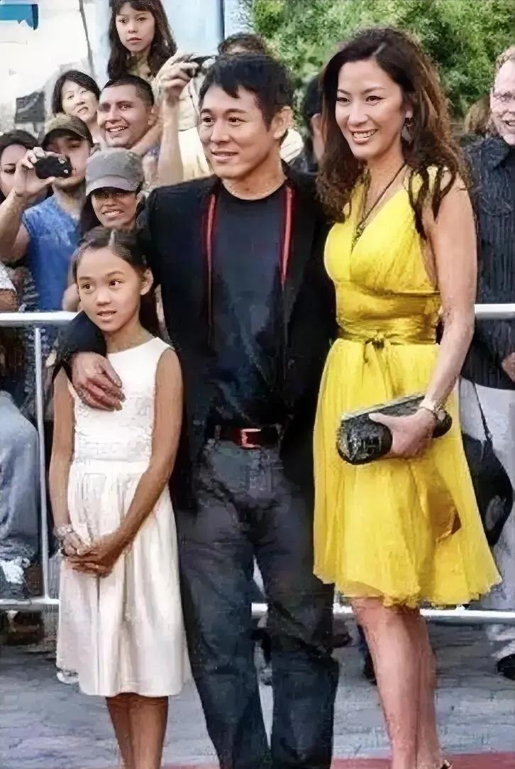 李连杰带着年幼的女儿走红毯，小姑娘穿着一条白裙子，一双黑皮鞋，打扮的很朴素，跟在