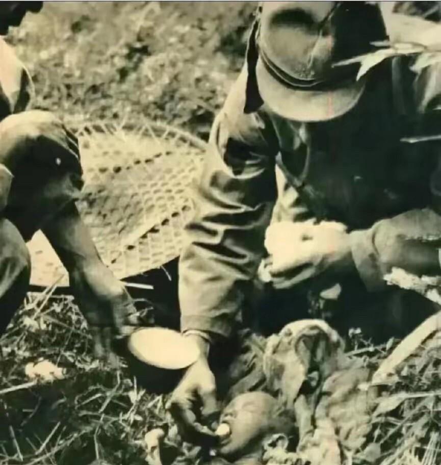 1937年的南京，一名日本兵把鸡蛋塞进婴儿嘴里，而旁边的另一名日本兵则举起一个杯