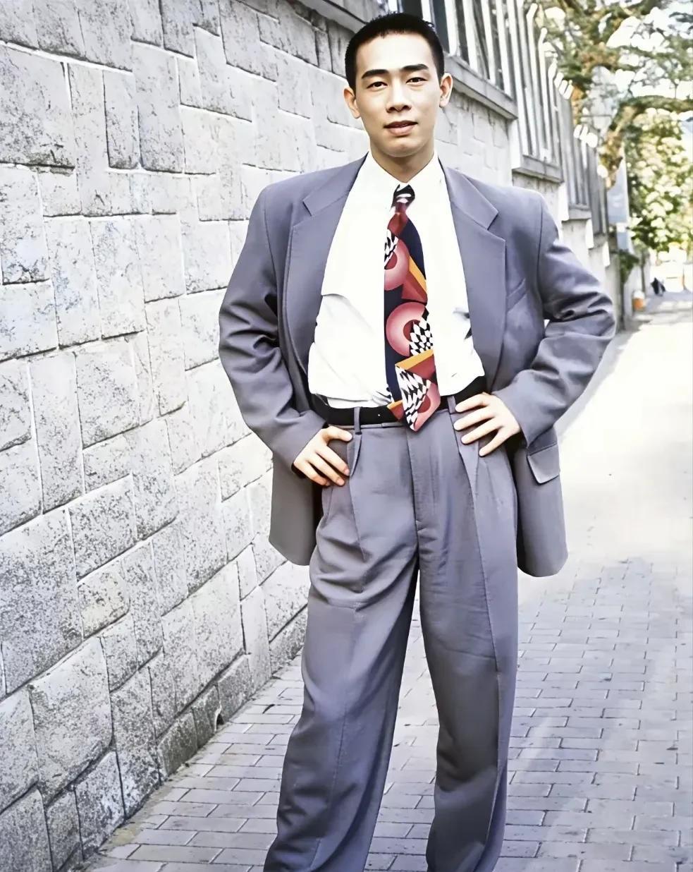 1992年，年轻时的陈小春留影。彼时的他正值二十五岁的青春年华，穿着挺阔的灰色西