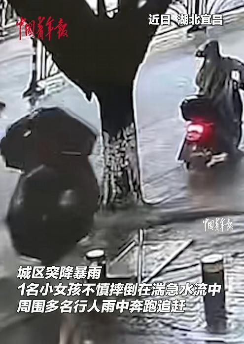 湖北宜昌，城区暴雨倾盆，一名小女孩被湍急的水流冲走，眼看就要被卷进下水道口，命悬