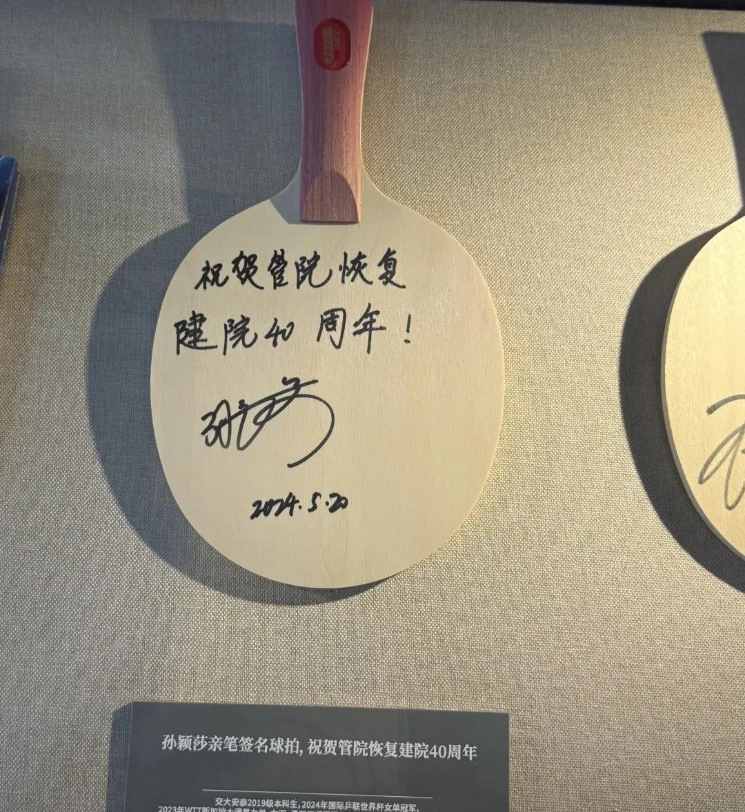 这是豆包给自己母校，上海交大管理学院的签名球拍。
有心细的网友看了说，豆包写错了