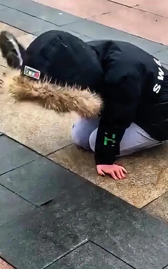 在早市大门口，一个年轻女子坐在地上痛哭不停，吸引了很多人围观。
女子是农村人，知