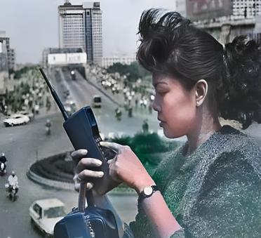 这是1987年广州一名先富起来的女士。这名女士烫着卷发，戴着小手表，手持大哥大。