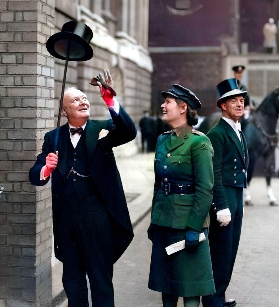 1943年，丘吉尔将自己的帽子用文明棍顶起来，一旁的女儿玛丽·丘吉尔看着“老顽童