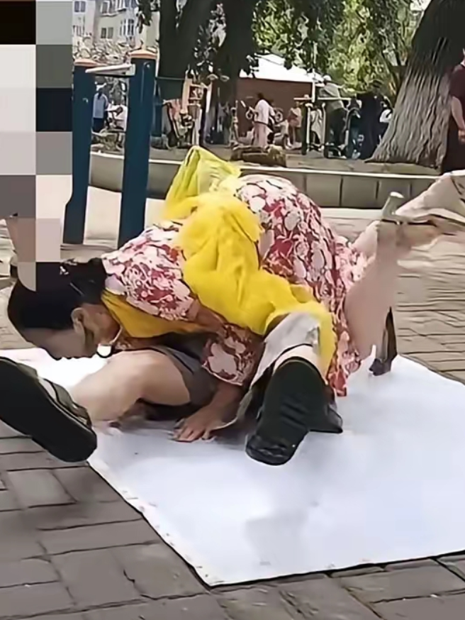 这是咋回事啊
公园里一老头和老太太在地上铺一朔料布，两个人在一起滚来滚去。公园里