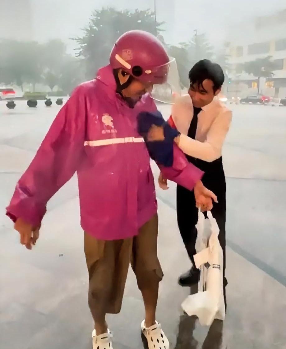 外卖小哥冒着大雨来送外卖，可到门口时却被拦了下来，一位年轻帅气的工作 人员急忙上