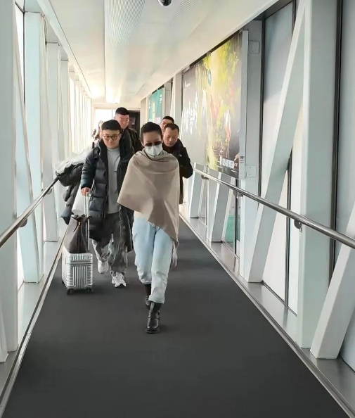秦海璐西安机场现身引发全网激辩，黑衣保镖开道、助理推行李阵仗十足，面对男粉一路狂