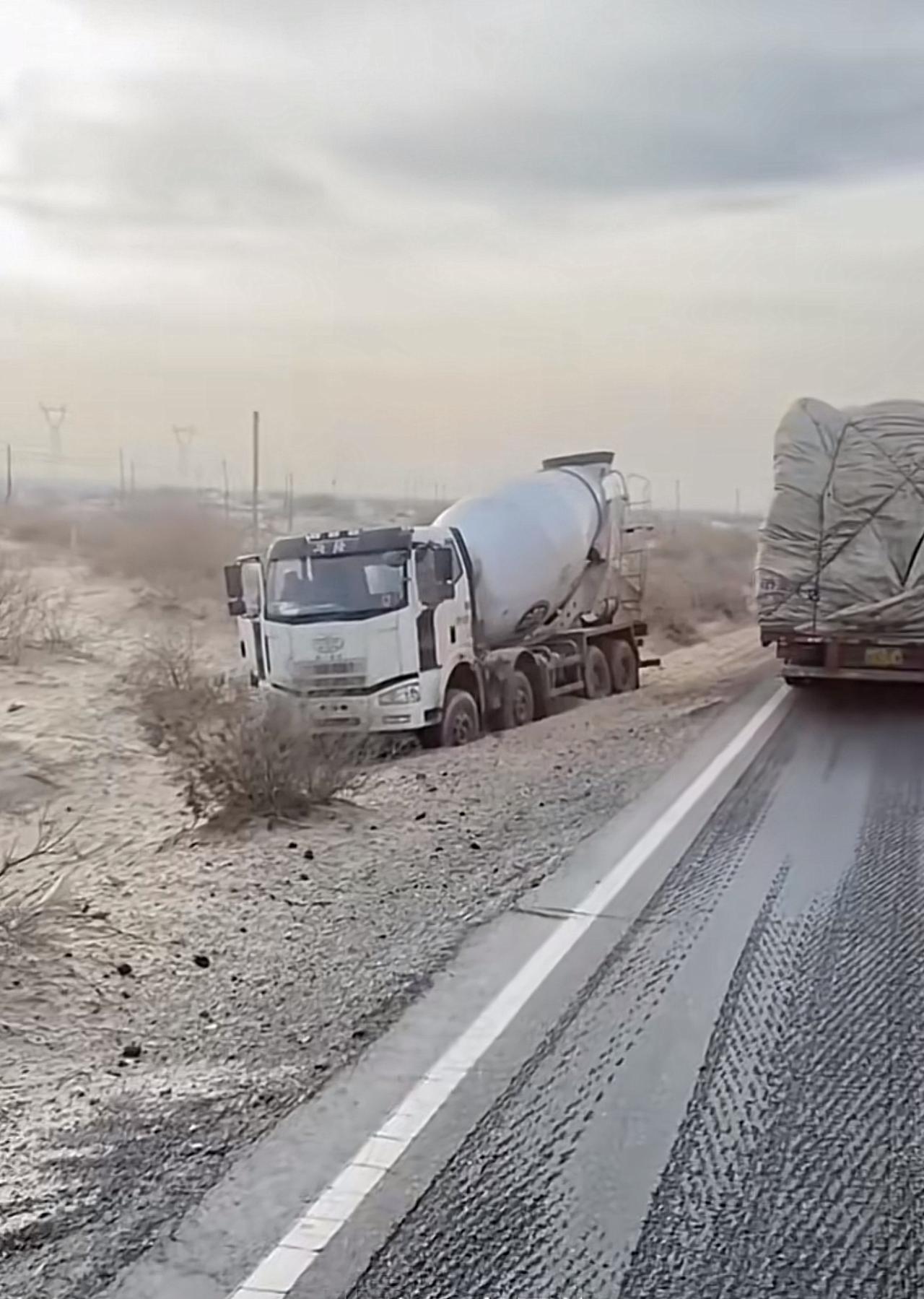 荒漠公路上的水泥车陷入沙里。今天再做一个好事帮卡车拉出来！