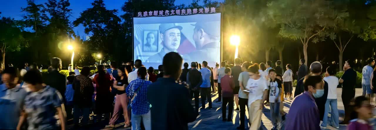 盛夏的夜晚，武威西郊公园广场，众多的老人小孩聚集在一起观看露天电影。这夏夜的露天