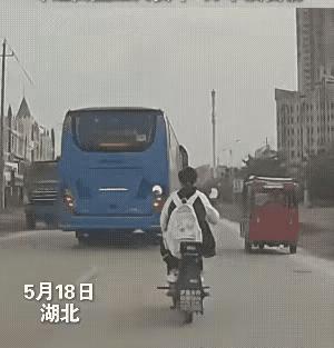 女中学生骑电动车逆行，险被撞！画面中，一辆公交车正行驶在马路上。一名骑着电动自行