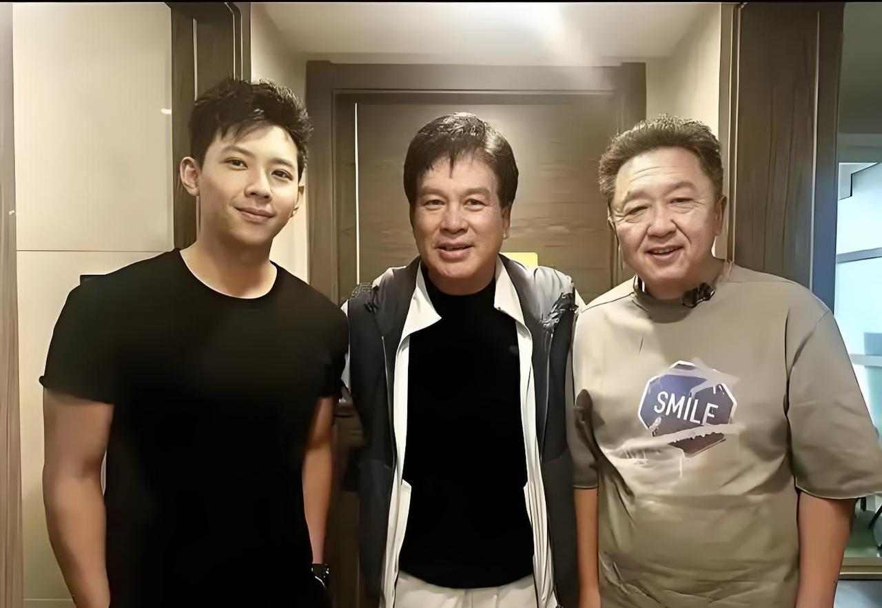 这是德云社著名相声演员于谦，与影星朱时茂父子的一张合影照片。
只见三人，气质优雅