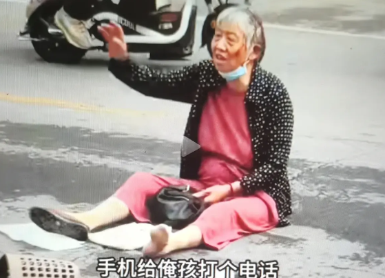 一老太太坐路中间，疑发生碰撞事故！欲借用路边女孩打电话给家人，被多个围观者大声制