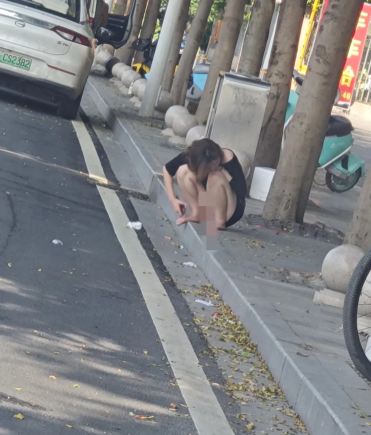 城市街头的孤独瞬间，她蹲在路边，心事重重。