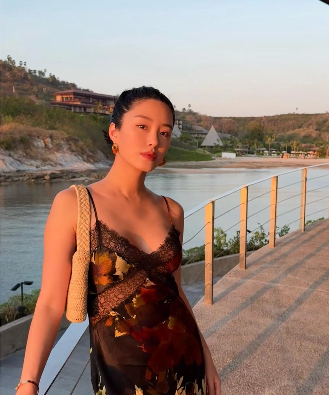 杨采钰穿吊带裙度假，她吃面包的样子很做作，产后一个多月身材完全恢复了……
修身吊