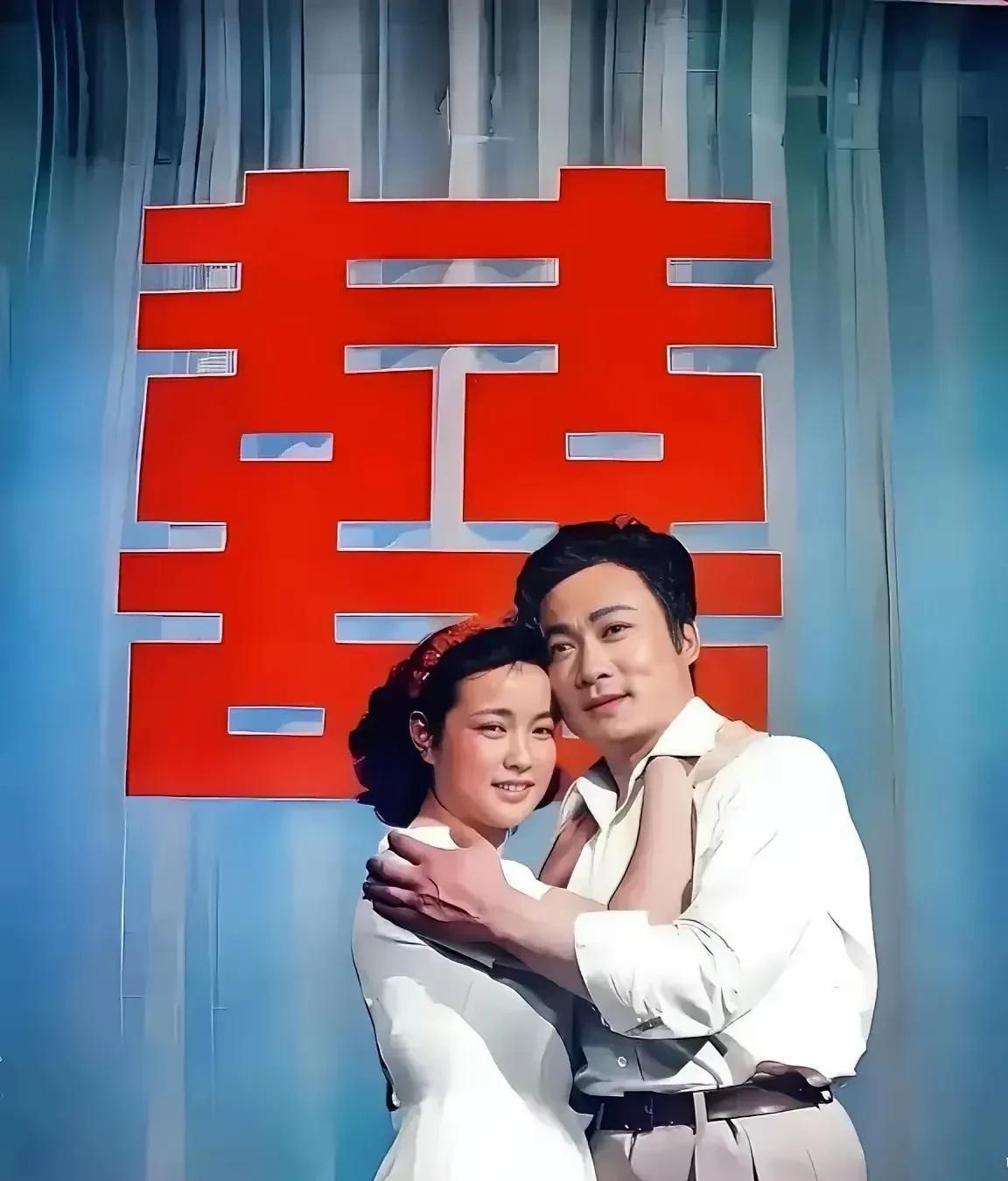 这是刘晓庆的一张剧照，照片中他与一位男士相拥在一起，后面是一个大大的喜字，可能在