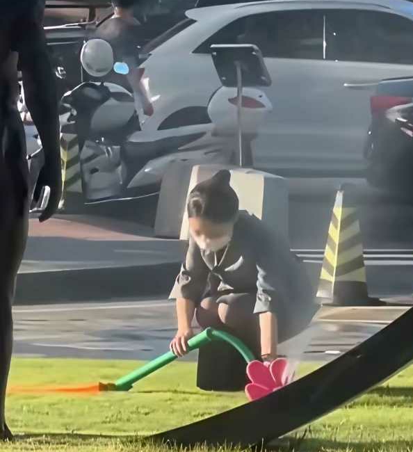 小姐姐看到草坪上的花洒倒在地上，赶紧上前扶起，下一秒：...快跑！