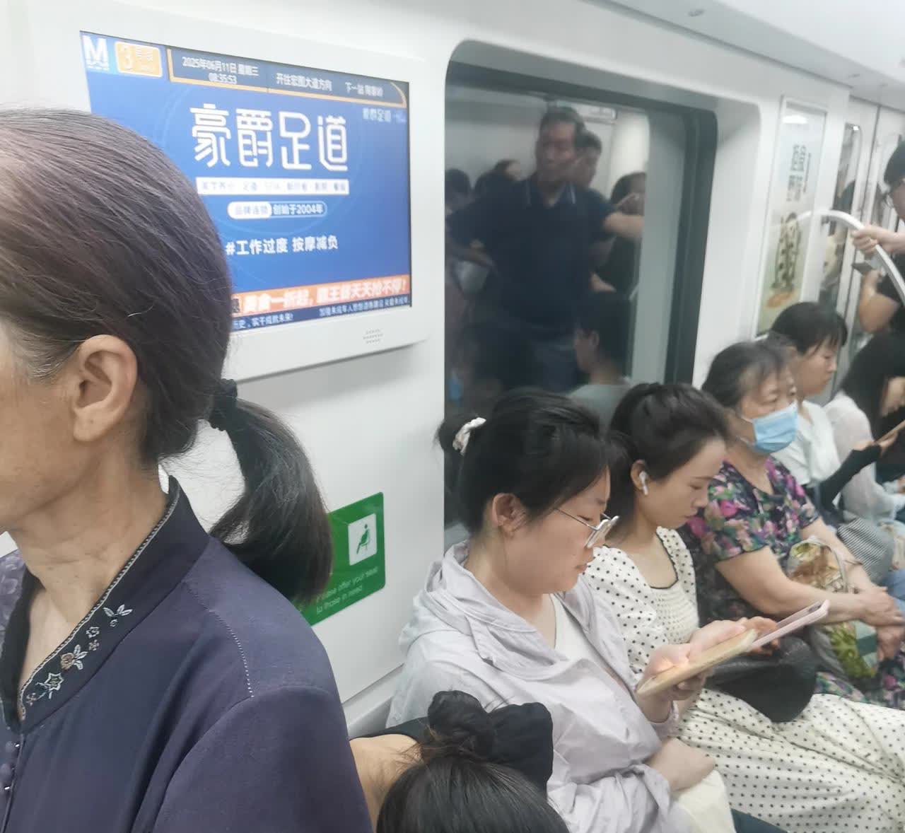 下图：  白发老人靠着"老弱病残六人座爱心椅”站着。青年姑娘稳稳当当地坐着，低头
