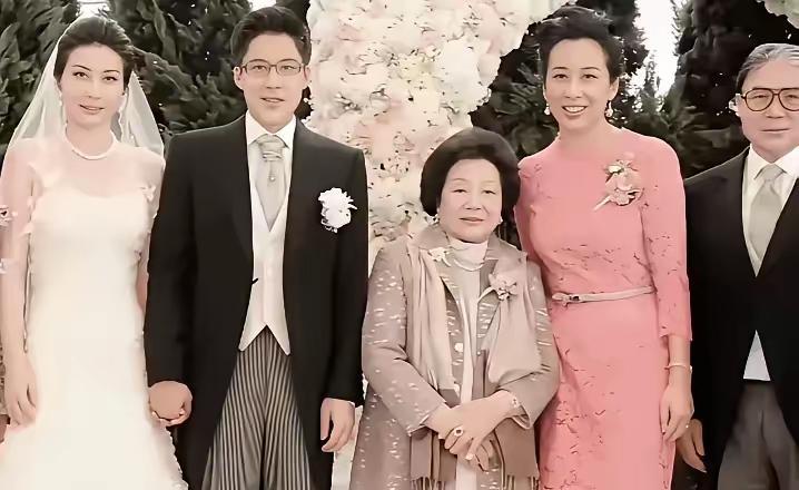 这是郭晶晶与霍启刚的婚礼照，他们分别穿着婚纱和西服，手挽着手，充满着新婚的甜蜜。