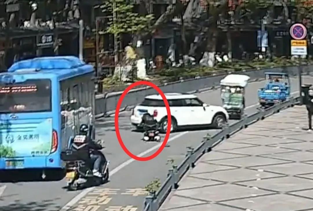 浙江景宁街头，车来车往。突然，一老人坐着轮椅，冲进车流，周围车辆纷纷急刹、避让。