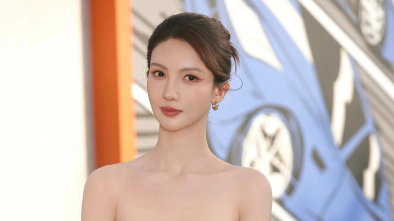 金晨一袭薄荷绿抹胸礼服与现场 26 款新车形成「香车配美人」的视觉盛宴。