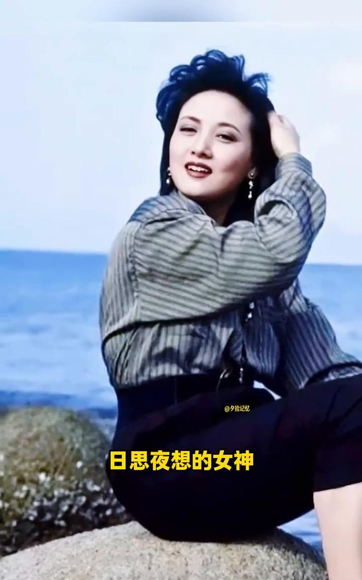 这是一代女神邓婕年轻时在海边的一张留影老照片，纯天然的美女真的太美了。在那个没有