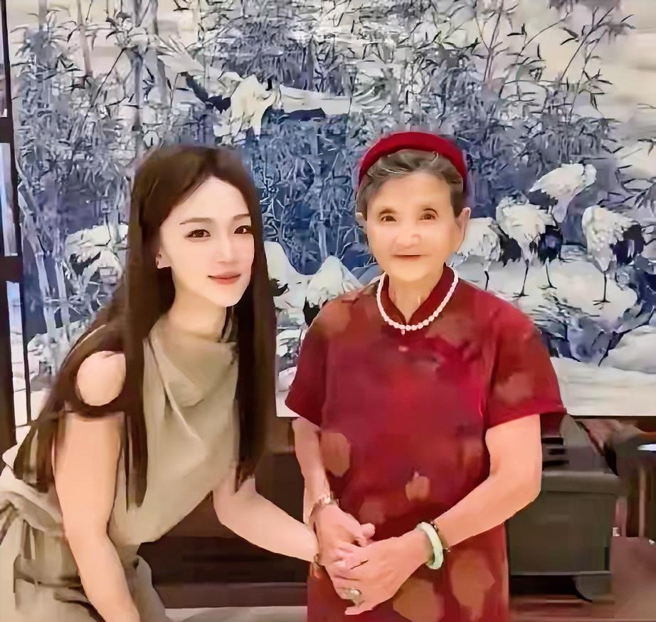 黄圣依的婆婆，红旗袍配红发卡，端庄大气，很好奇手里牵的女孩是谁，看着好美