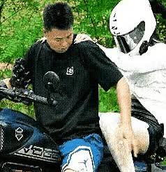 第一辆摩托车坐着一男一女两个，后座上的女子紧紧搂着前座上的男子，前座上的男子还嫌