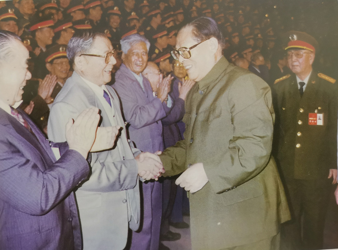 江同志和老将军向守志亲切握手，向守志旁边是张铚秀，他们都当过大军区司令员，江同志