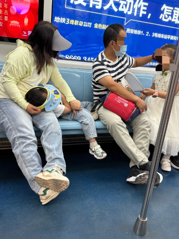这是前天中午12点半，地铁1号线上的一幕：两口子带了两个小孩，女的旁边躺了一个小