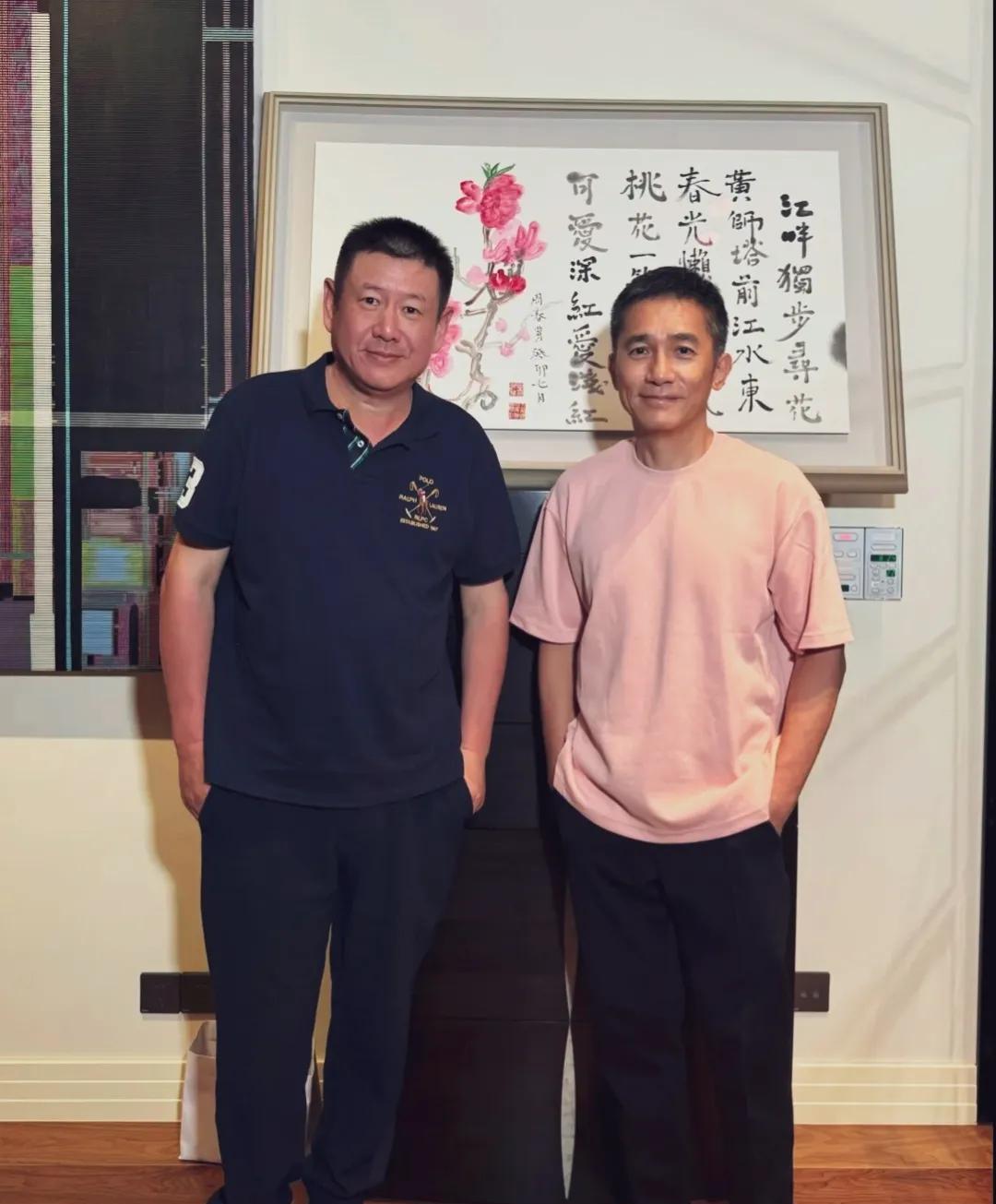 这俩人看着有点意思！都双手插兜，满脸社恐相！梁朝伟个子不高，粉色T恤，面露浅笑。