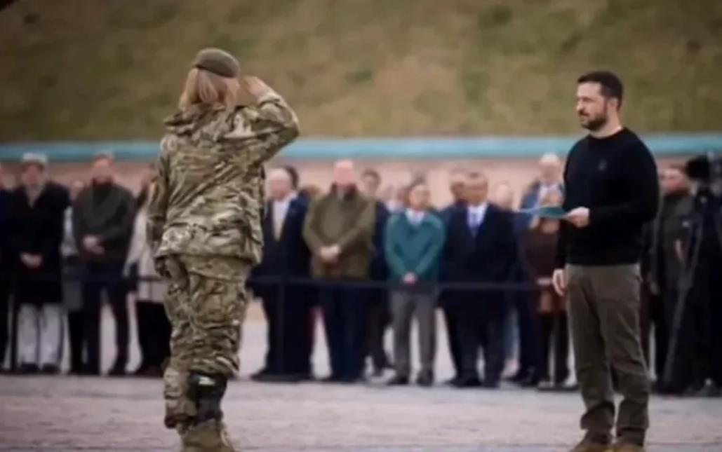 一名女战士向斯基总统敬礼，她们就要奔赴前线打仗了，演员出身的斯基总统给她跪下了，