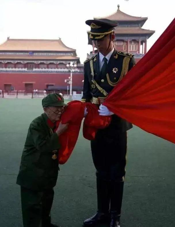 这是抗战英雄李安甫受邀到北京天安门观看旗仪式时，亲吻国旗拍下的珍贵照片，也是网上