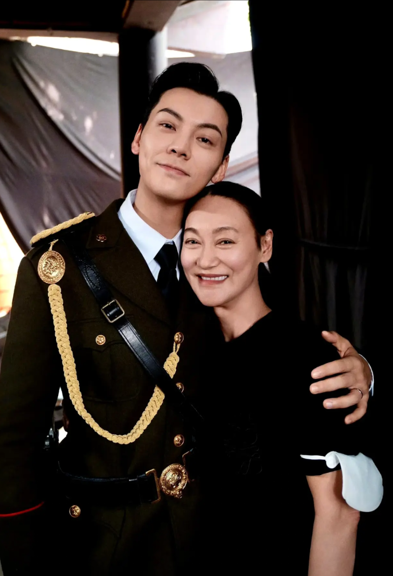 惠英红在探班《九门》剧组时，不仅与主演陈伟霆互动，还贴心请全剧组喝饮料，展现了前